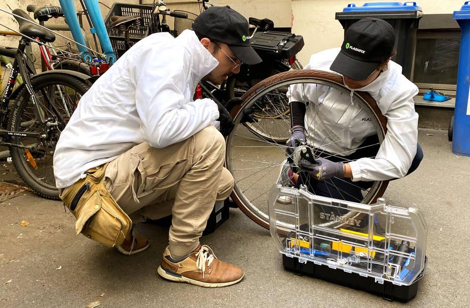 A bike mechanic repairing a bike wheel.